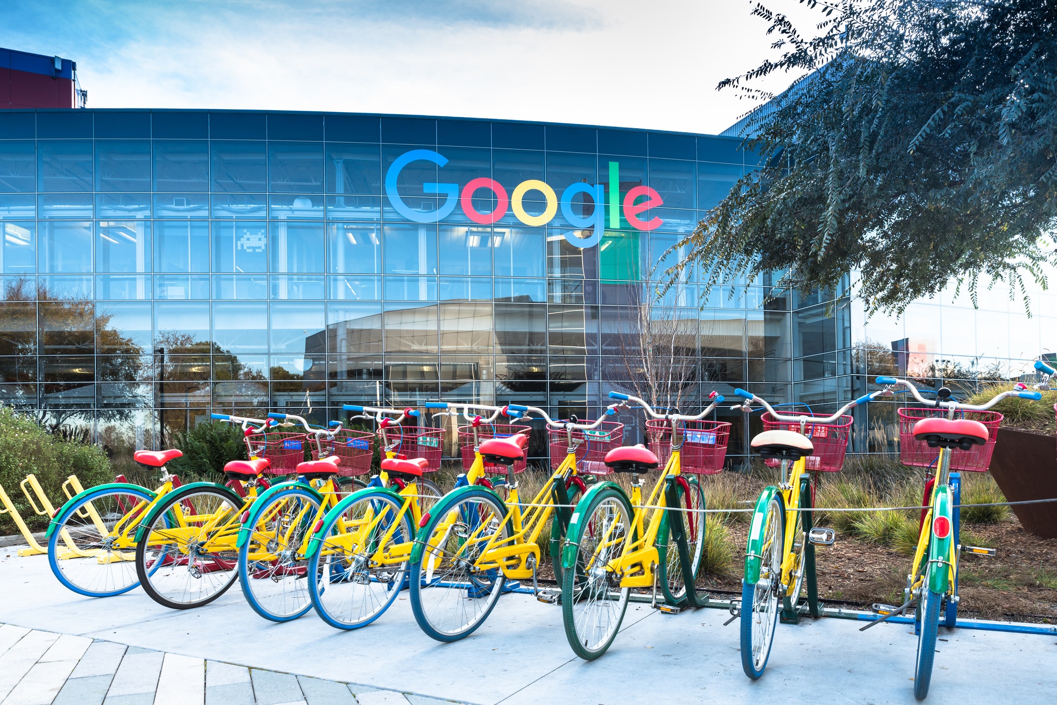 A photo of Google HQ in Mountain View, California, with red, yellow, blue, and green bicycles parked in the foreground for google updates coming in 2023 blog.