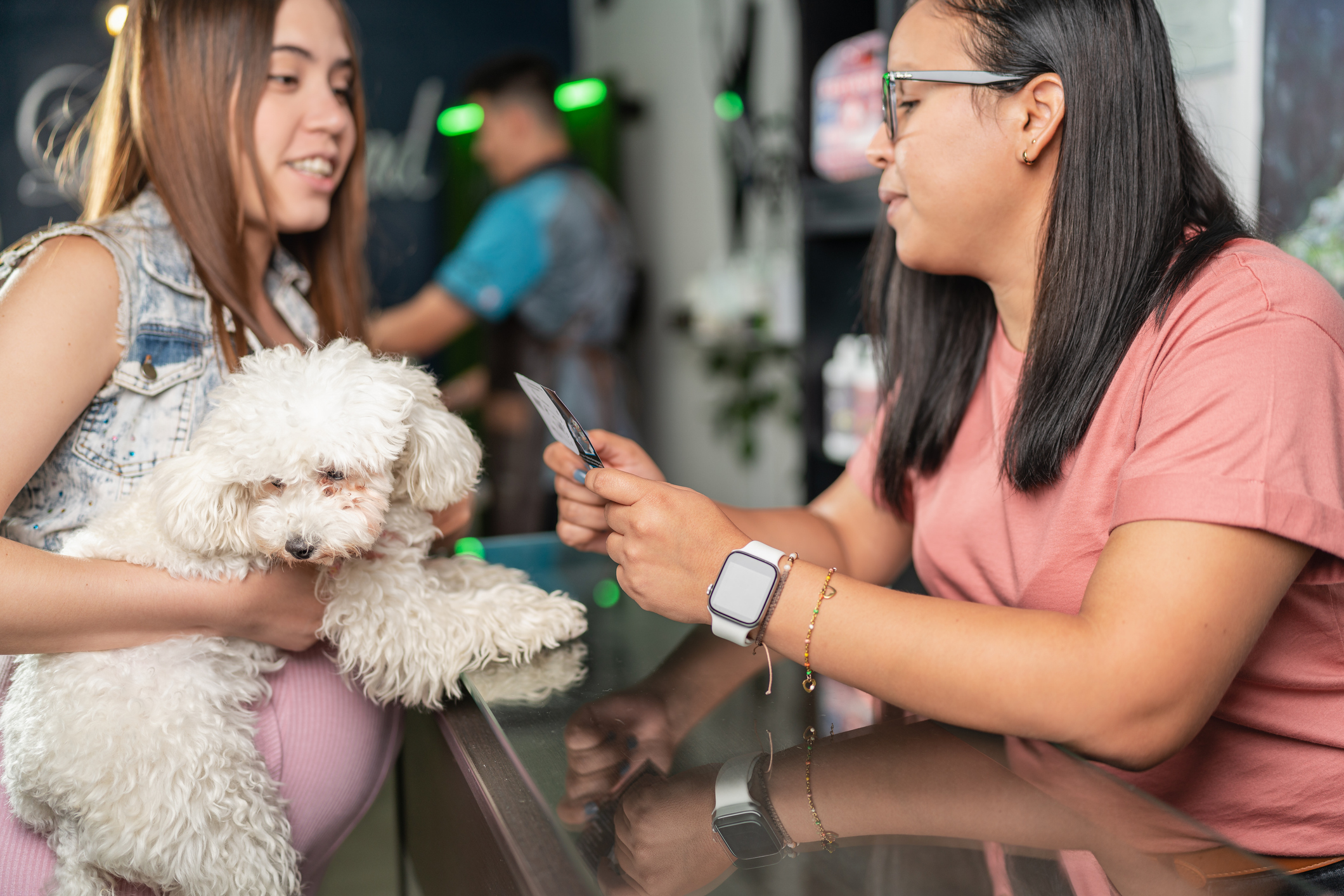 Close up photo of a Latina woman attending a costumer with a dog at a pet resort for SEO-for-pet-care blog.