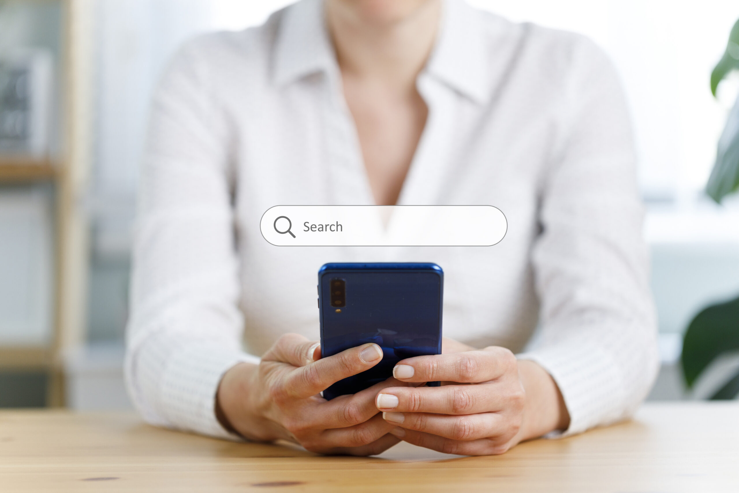 A businesswoman conducts a search on a smartphone for google-ads-brand-campaigns blog.