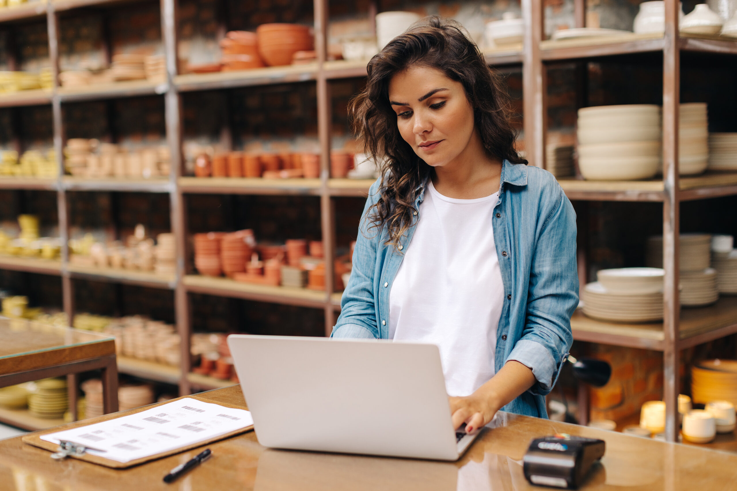 A young female entrepreneur manages online orders for her her ceramics shop for google-business-profile-q&a blog.