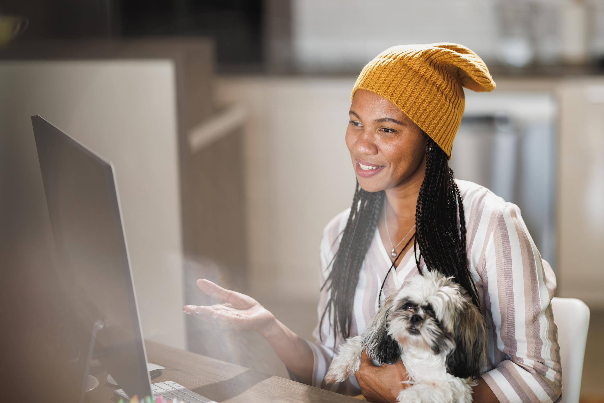 A business woman and her dog work on the computer at a home office for multi-location-facebook-pages blog.